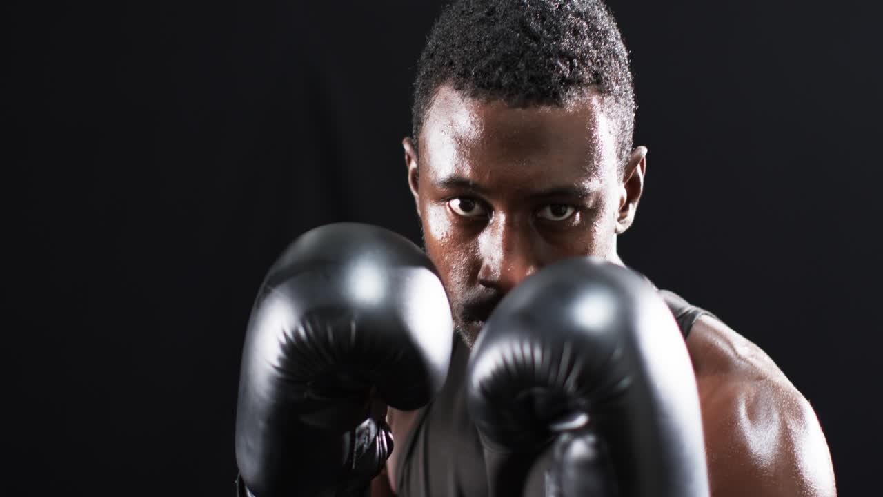 boxeador afroamericano listo para luchar en el ring sobre un fondo negro