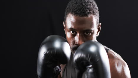 boxeador afroamericano listo para luchar en el ring sobre un fondo negro