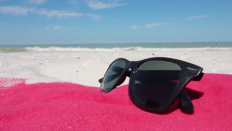 Schwenkaufnahme-Einer-Sonnenbrille-Am-Strand-In-Naples,-Florida