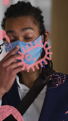 animation of pandemic icons over biracial man with face mask