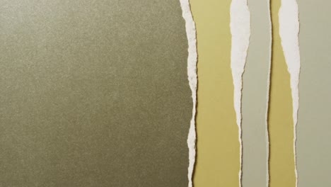 Video-of-close-up-of-torn-pieces-of-green-and-brown-paper-background