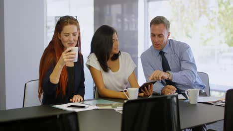 colegas de negocios discutiendo sobre una tableta digital 4k