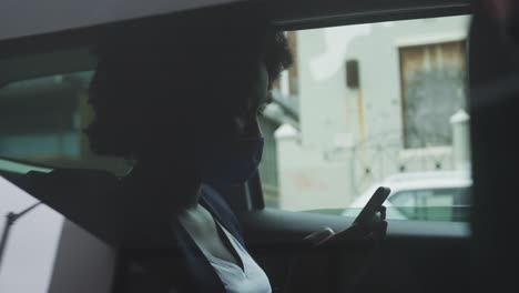 african american woman wearing face mask in car