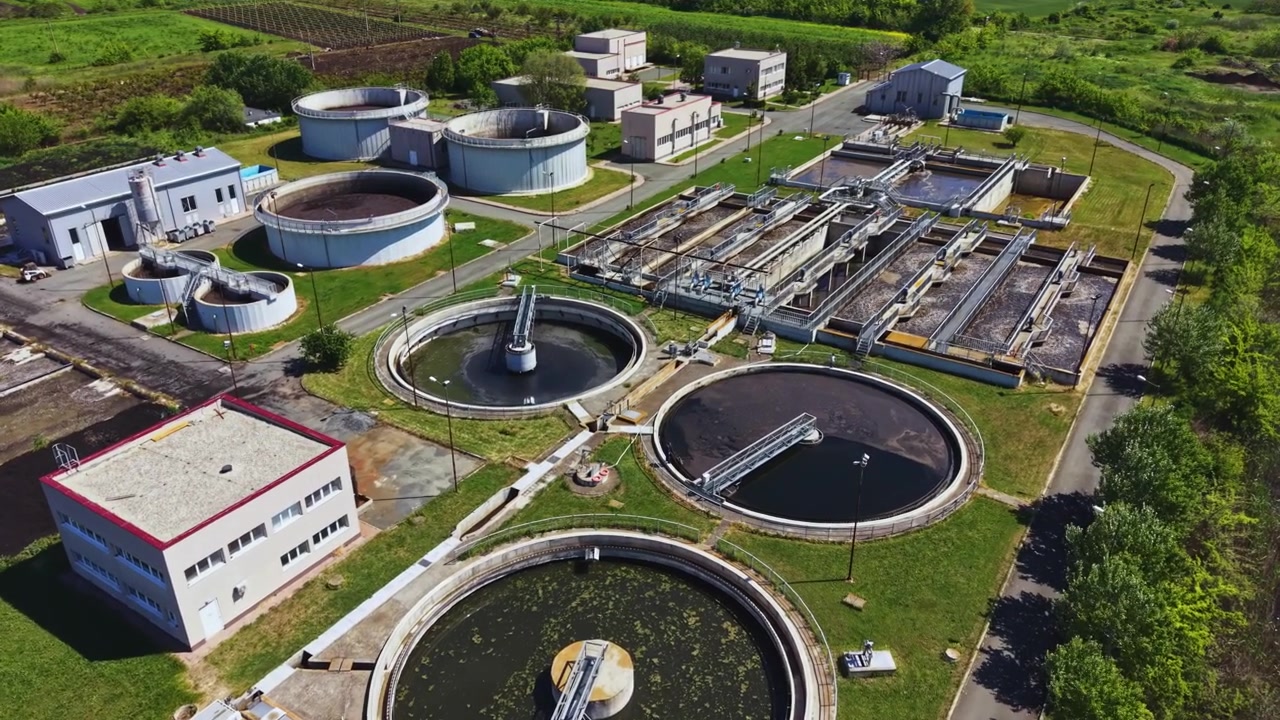 Circular clarifiers and infrastructure for clean water processing. Observational drone shot showcasing municipal sewage treatment facilities and environmental safeguards