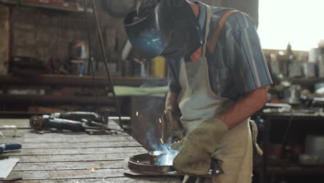 Blacksmith-Welding-Metal-in-Workshop