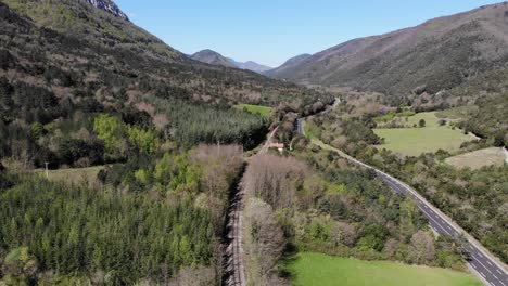 Aerial:-red-and-white-old-train-in-a-forest-in-southern-France