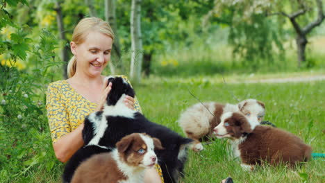 Young-Caucasian-Woman-Playing-With-Several-Puppies-In-Her-Backyard