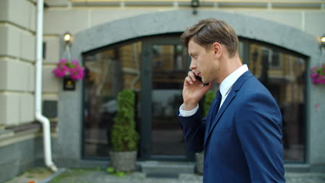 stressed business man talking mobile phone outdoors