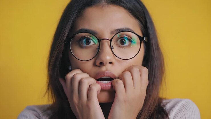 A woman with a surprised expression wearing glasses