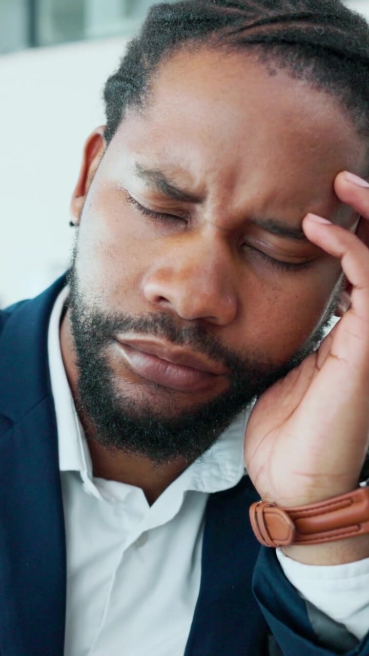 Stressed Businessman Rubbing His Temples in Office