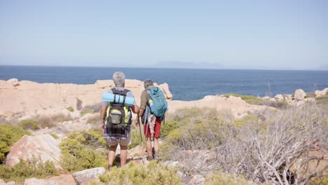 una feliz pareja biracial en las montañas haciendo senderismo, en cámara lenta