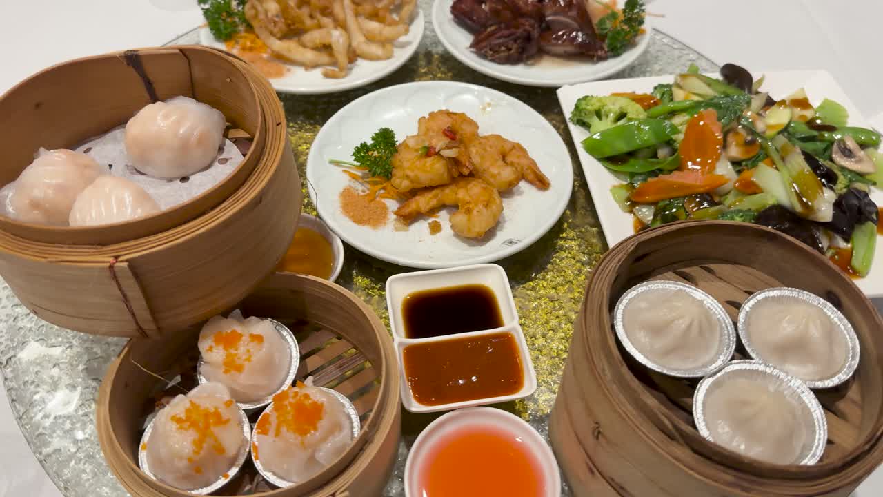 A vibrant display of dim sum and Chinese cuisine on a rotating table, highlighting diverse dishes and sauces