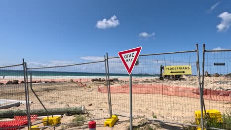 sitio de construcción frente a la playa con señales de seguridad y cercas