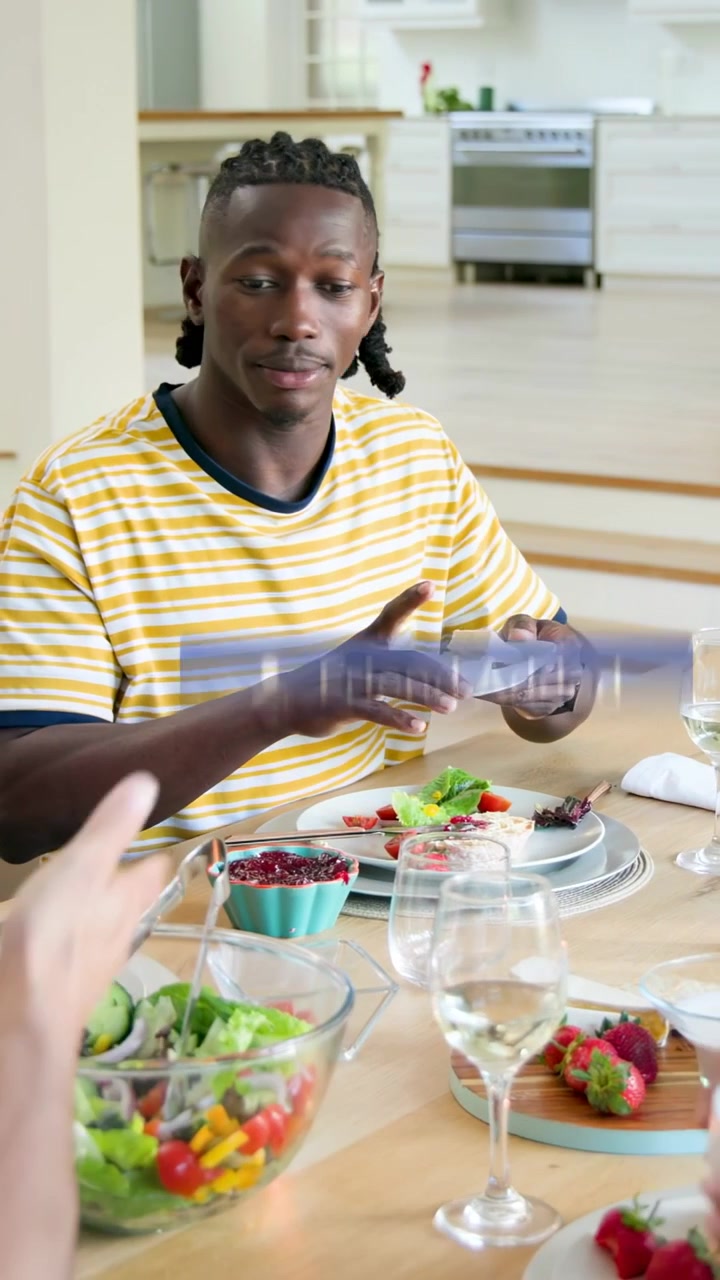 Vertical video: Man plating salad in yellow tee, reacting to social alerts appearing, then serving