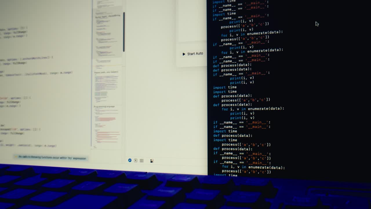 Programmer Typing Code on a Computer Screen with Illuminated Keyboard
