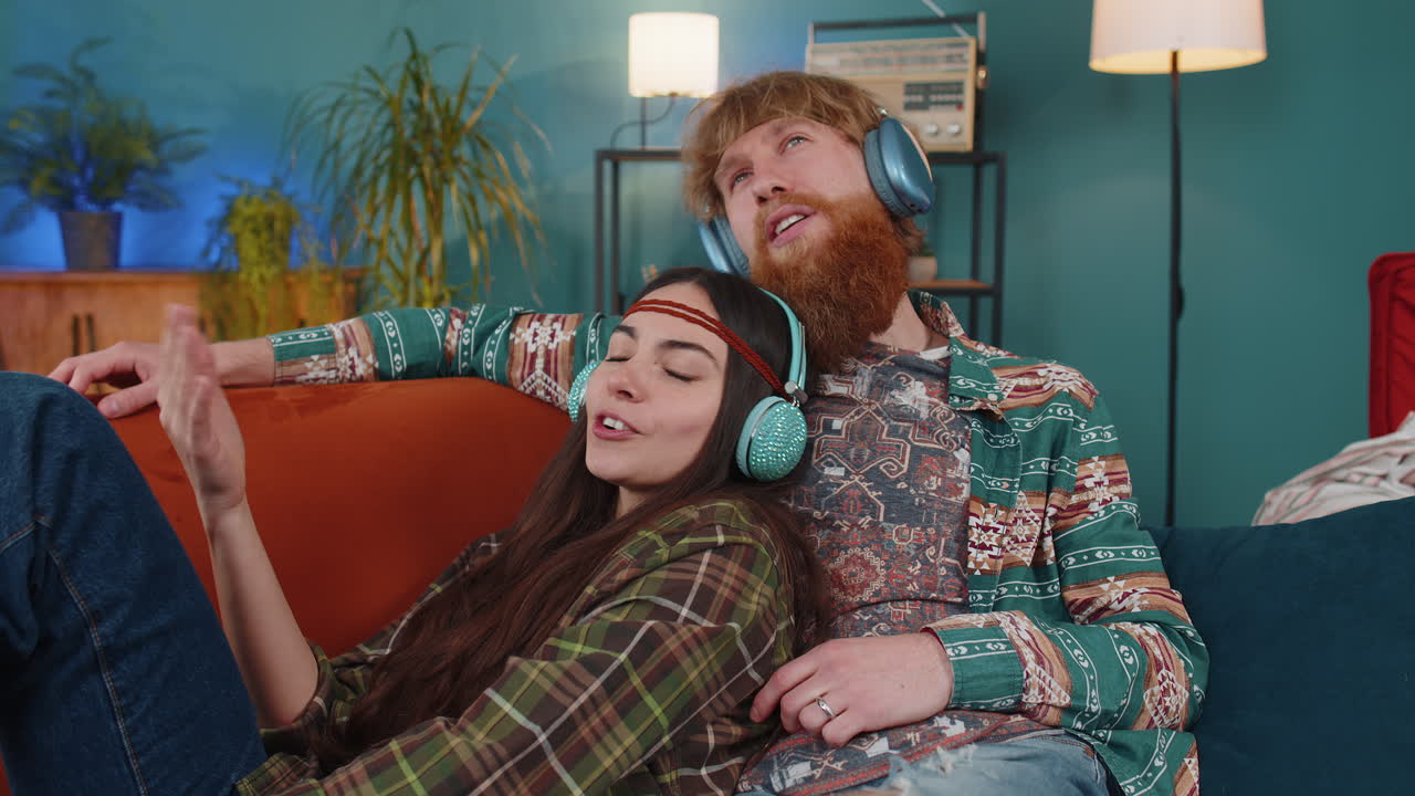 가족 남자 여자 무선 헤드폰 춤추고 집 소파에서 좋아하는 록 앤 롤 음악을 듣고