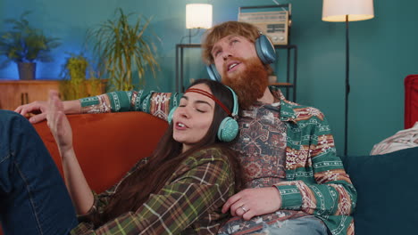 hombre de familia mujer con auriculares inalámbricos bailando escuchando música rock n roll favorita en el sofá de casa