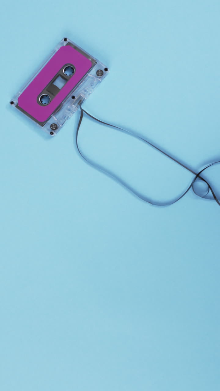 Vertical video of retro tape with pink label and copy space on blue background