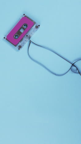 vertical video of retro tape with pink label and copy space on blue background