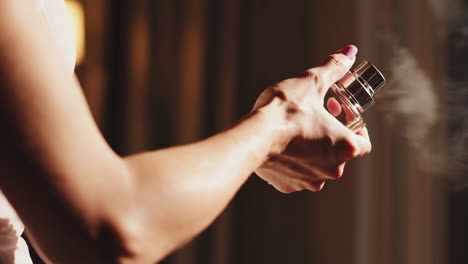 close-up of a hand spraying perfume from a bottle