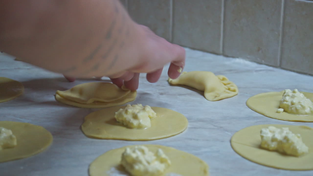 imágenes de primer plano de una mujer preparando pasteles de queso griego caseros