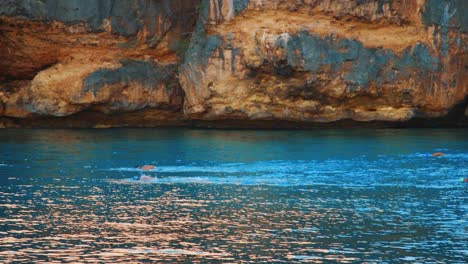 Slow-Motion-Pan,-Swimmers-racing-in-Caribbean-Spanish-Waters,-Curacao