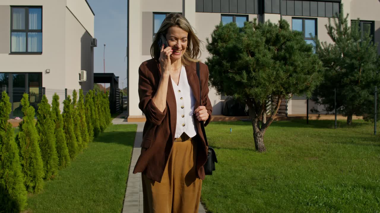 Donna che parla al telefono davanti a casa