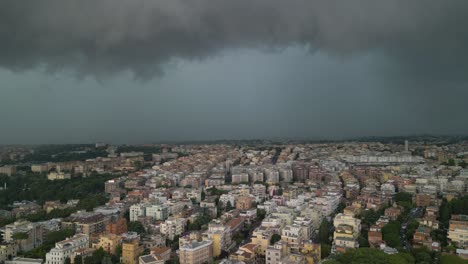 Aerial-drone-forward-moving-shot-over-rows-of-buildings-with-dark-rain-clouds-passing-over-the-city-of-Rome-in-Italy-on-a-cloudy-day