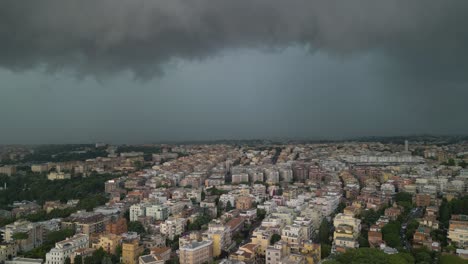 aerial drone forward moving shot over rows of buildings with dark rain clouds passing over the city of rome in italy on a cloudy day