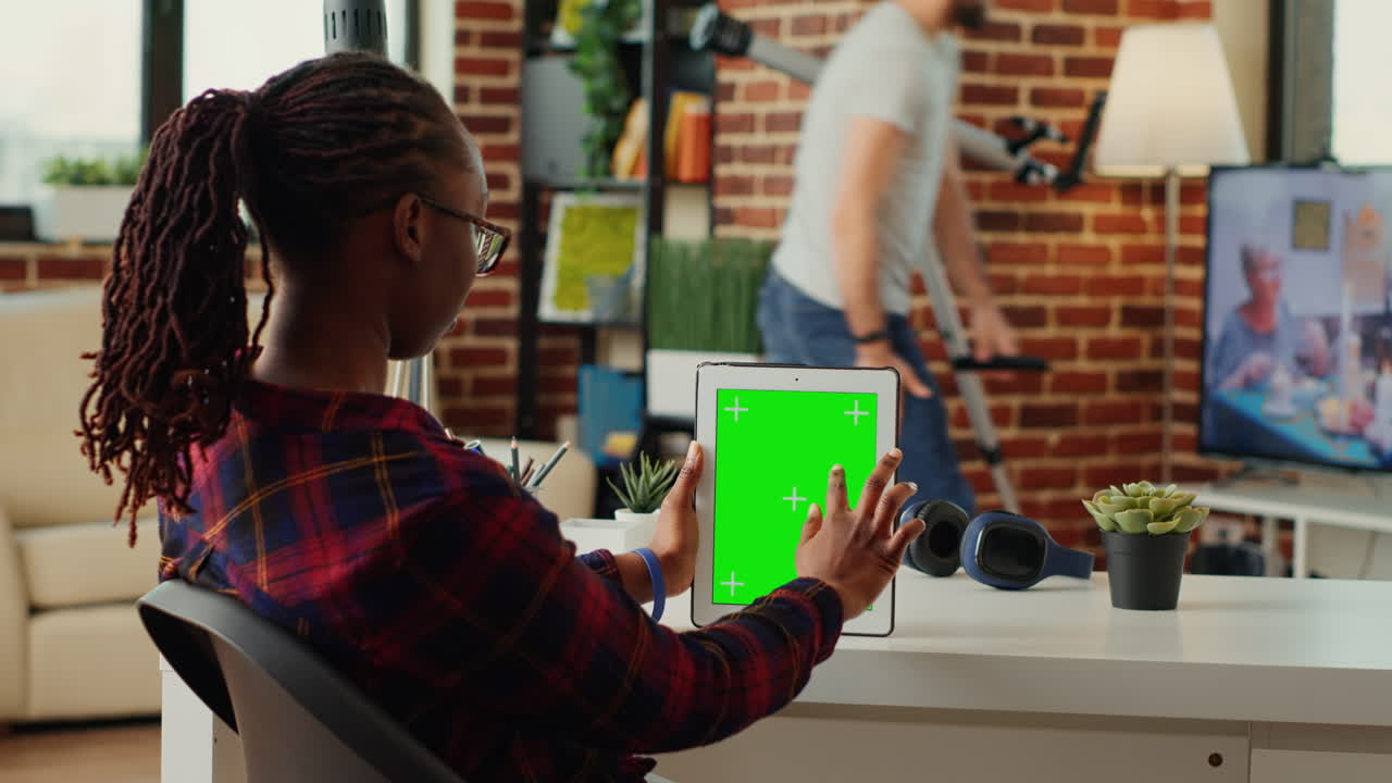 Office employee analyzing digital tablet with greenscreen display
