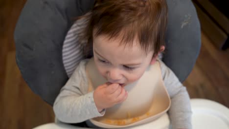 biracial hispanic latino white caucasian baby eating rice in a high chair 4k