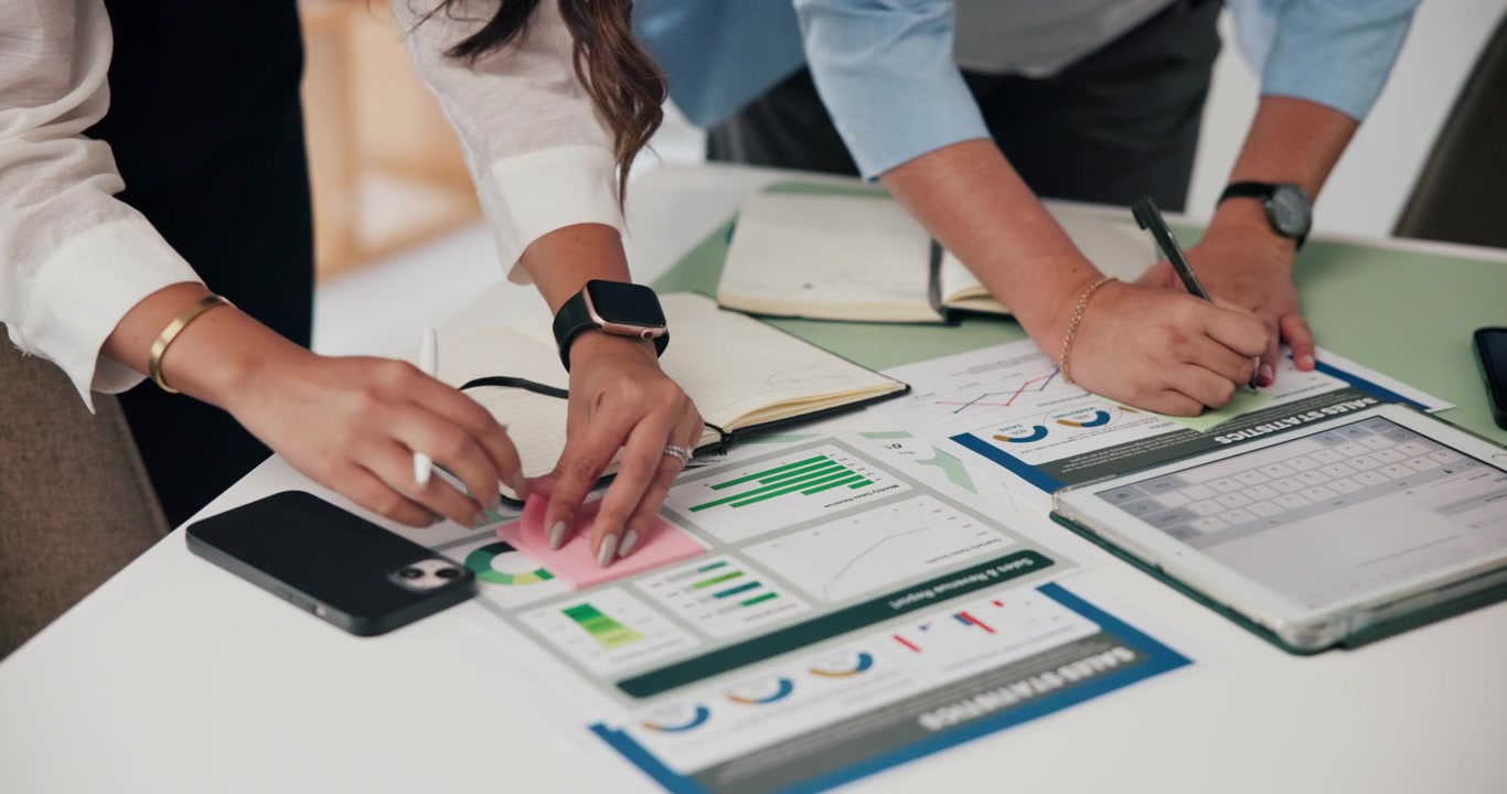 Business Colleagues Analyzing Sales Statistics and Financial Reports in Office