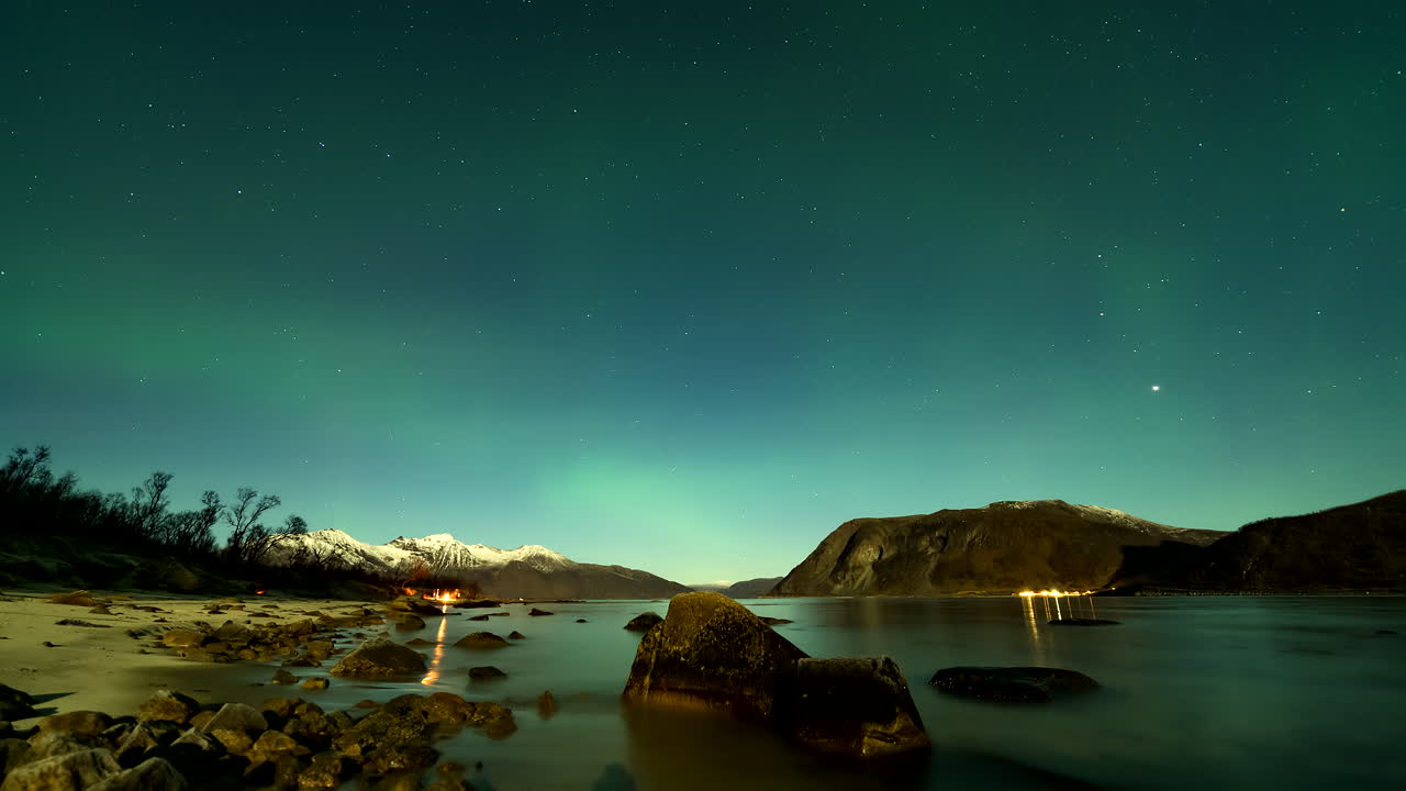 Mystical green aurora borealis dance in night sky over Grotfjord, timelapse