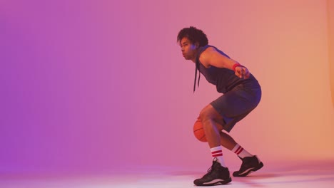 Video-Eines-Gemischtrassigen-Männlichen-Basketballspielers-Mit-Ball-Auf-Orangefarbenem-Bis-Rosafarbenem-Hintergrund