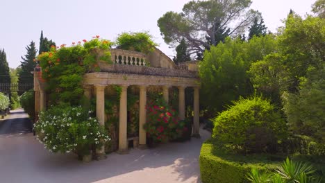 slow aerial orbit shot of a sandstone building at the driveway to the chateau de castille