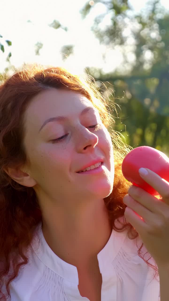 Woman enjoying an apple in a garden