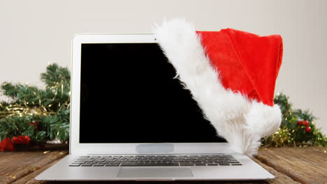 laptop with santa hat on a plank