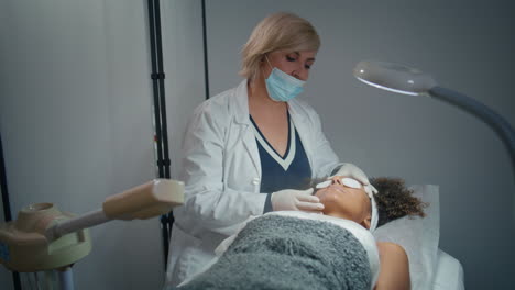 cosmético profesional que trata al cliente en el spa. paciente relajado en el spa