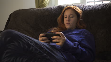 woman on couch using smartphone