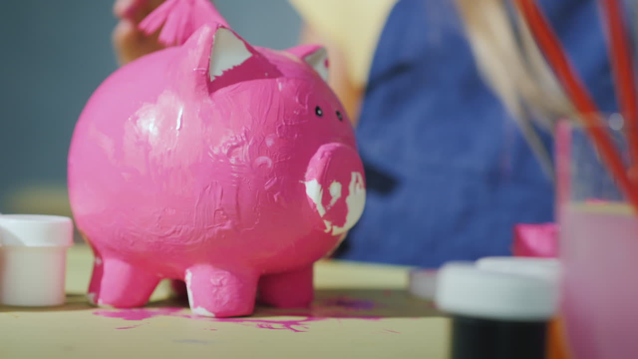los niños juntos pintan una alcancía en juegos de color rosa con el concepto de niños video 4k