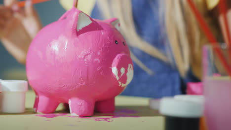 Kinder-Malen-Zusammen-Ein-Sparschwein-In-Rosa-Spielen-Mit-Kinderkonzept-4k-Video