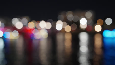 colorful bokeh of holiday lights during christmas boat parade on river at night