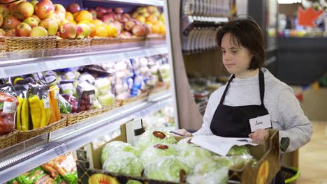 woman with down syndrome pushing trolley with fresh vegetables to restock the shelves