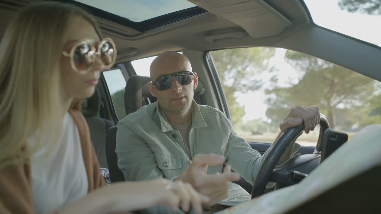 pareja feliz discutiendo la ruta en el coche