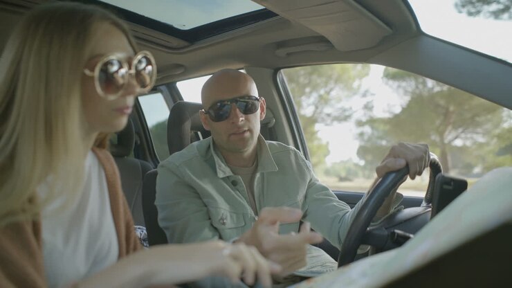 Coppia felice che discute l'itinerario in auto