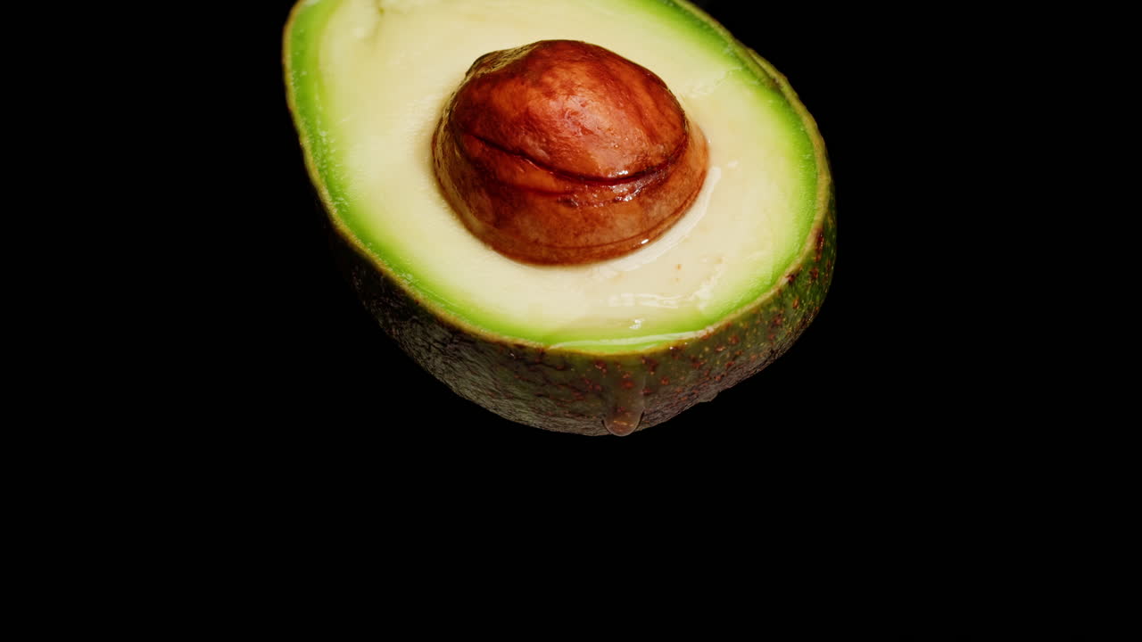 Primo piano di mezzo avocado con una goccia d'acqua