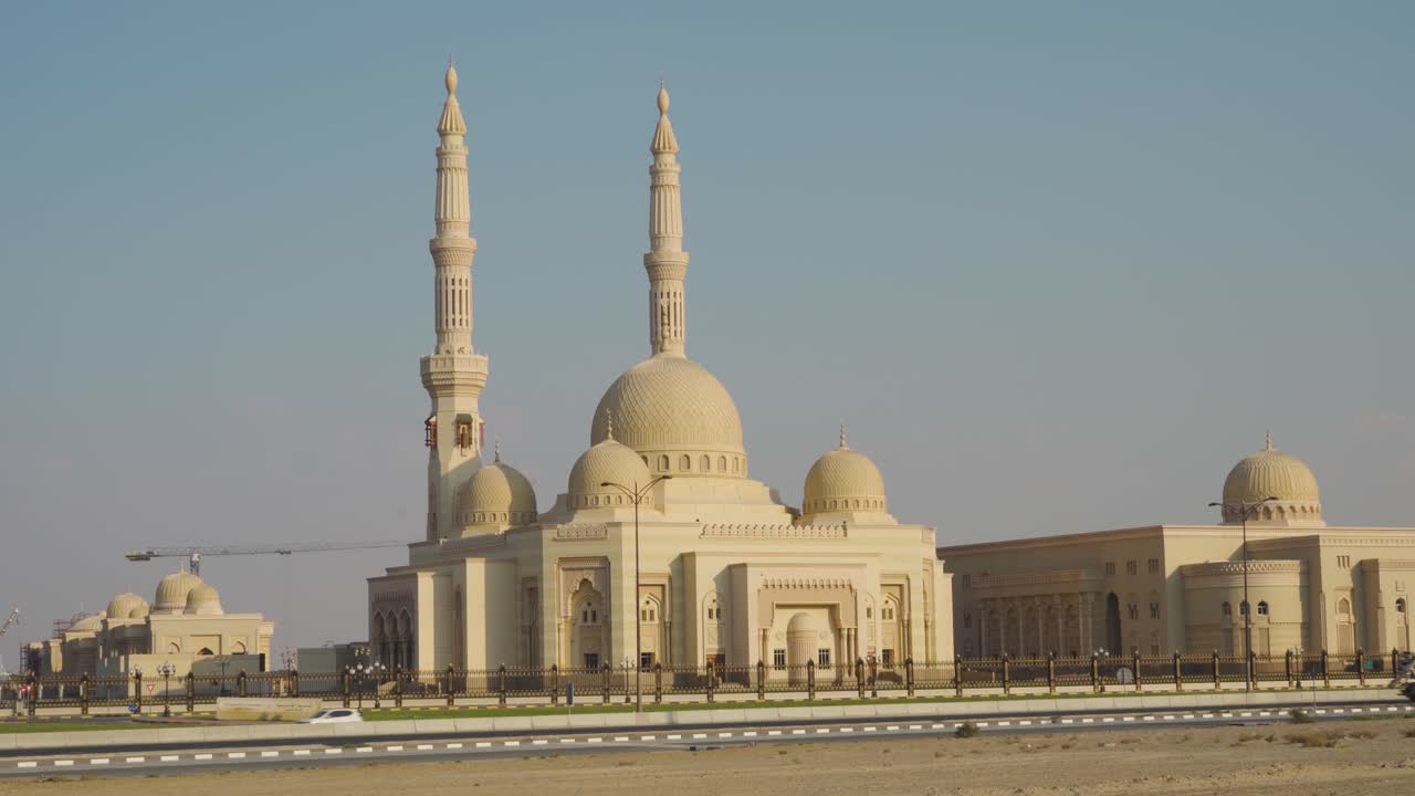 la mezquita de la universidad al qasimia con estructuras arquitectónicas cercanas en sharjah, emiratos árabes unidos - plano general