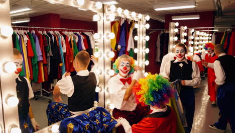 clowns getting ready backstage in a dressing room