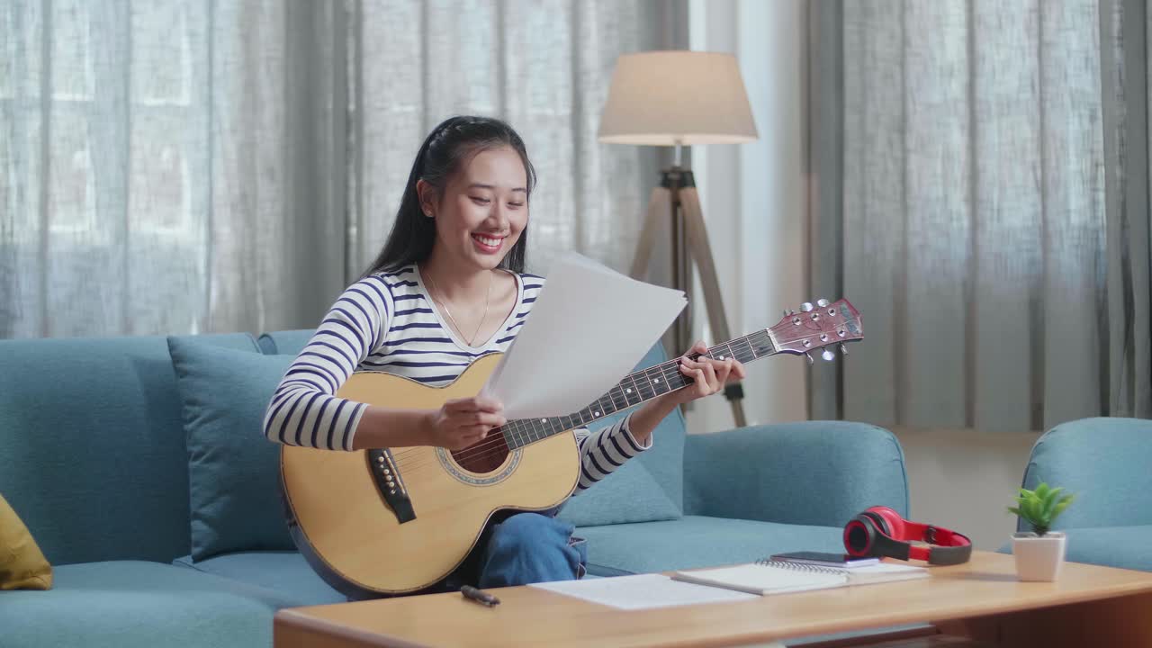 집에서 어쿠스틱 기타를 연주하는 여자