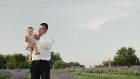 A-father-gives-water-to-a-little-daughter-to-drink.-Walk-together